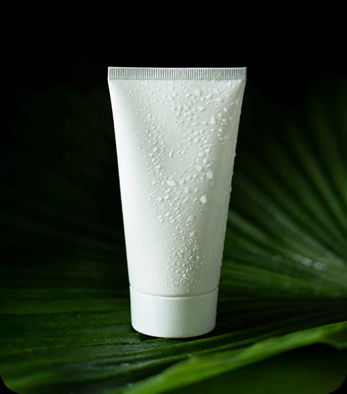 Unbranded white skincare tube on a dark green background